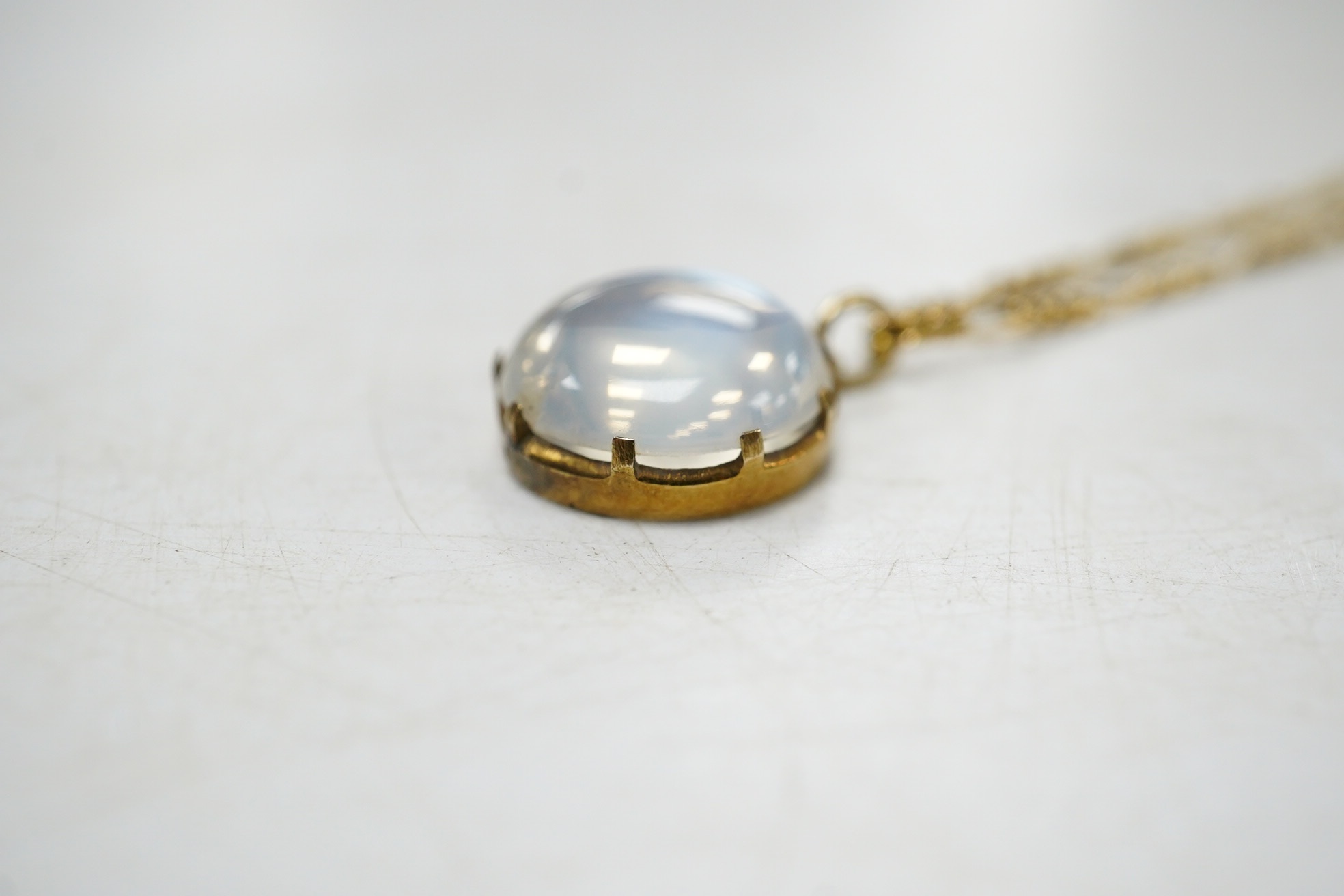 A yellow metal and single stone cabochon moonstone set pendant necklace, overall 42cm, gross weight 5.1 grams. Condition - fair